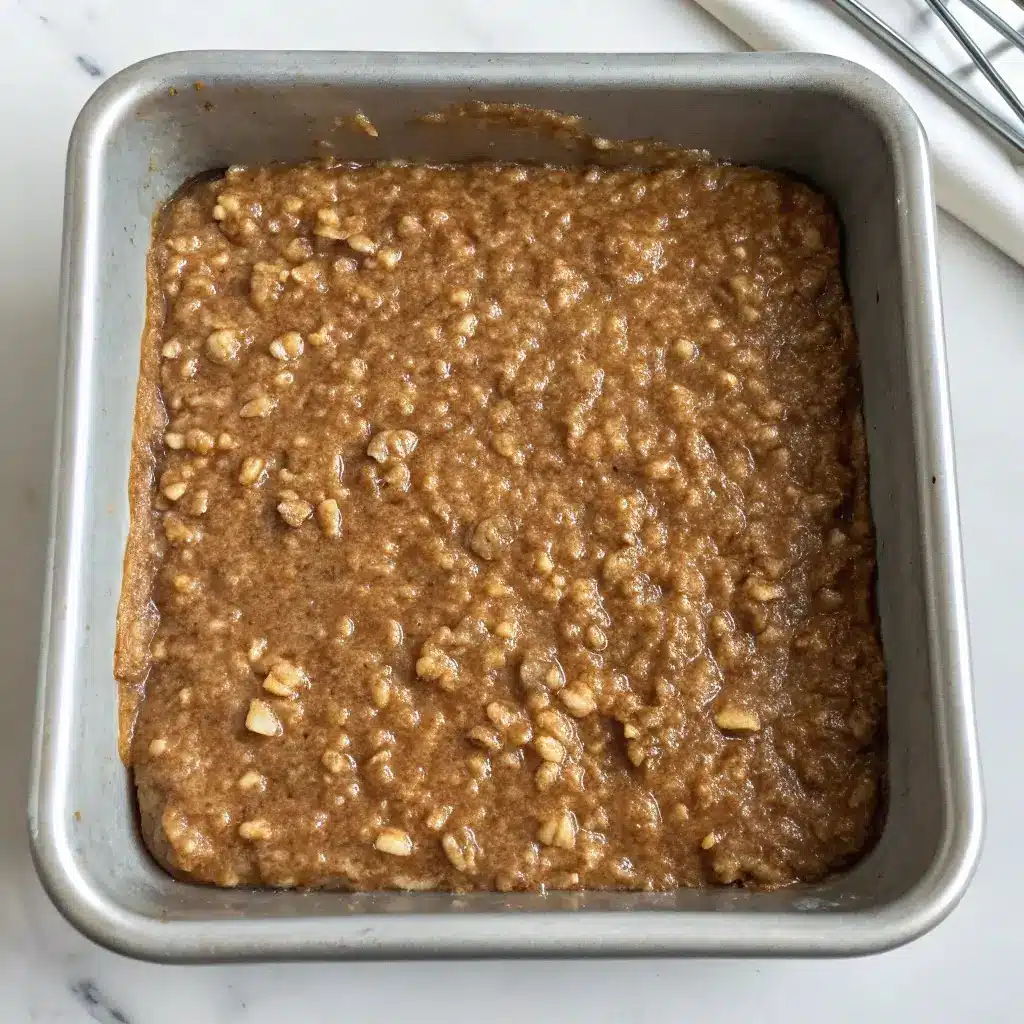 Unbaked coffee cake oatmeal mixture in a metal baking pan.