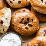 Cinnamon raisin bagels served with cream cheese on parchment paper
