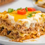 Plated slice of taco lasagna with noodles, ground beef, and melted cheese