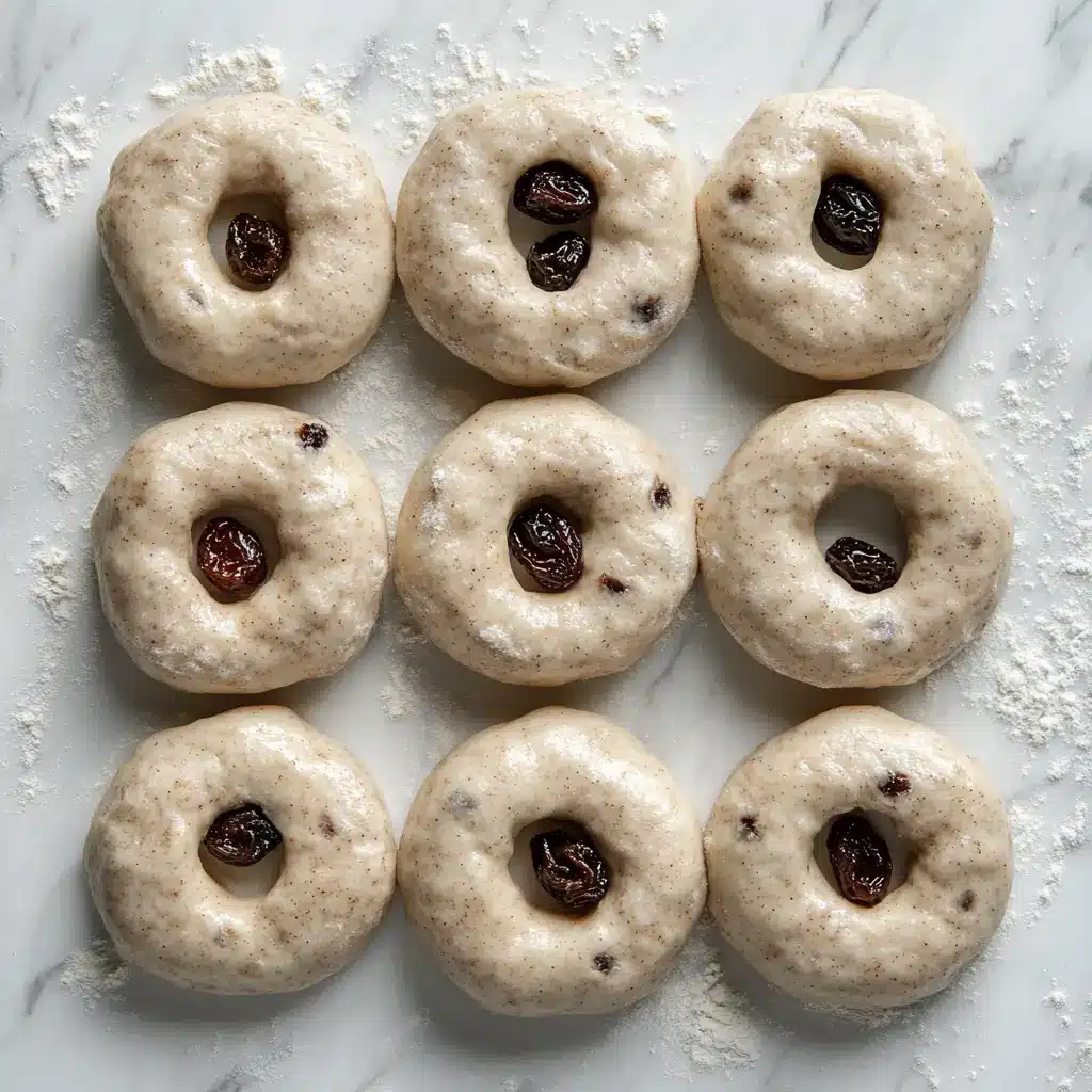 shaped-cinnamon-raisin-bagel-dough-rings Shaped cinnamon raisin bagel dough rings resting on a floured marble surface
